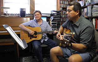 Photo of a fingerstyle acoustic guitar lesson.